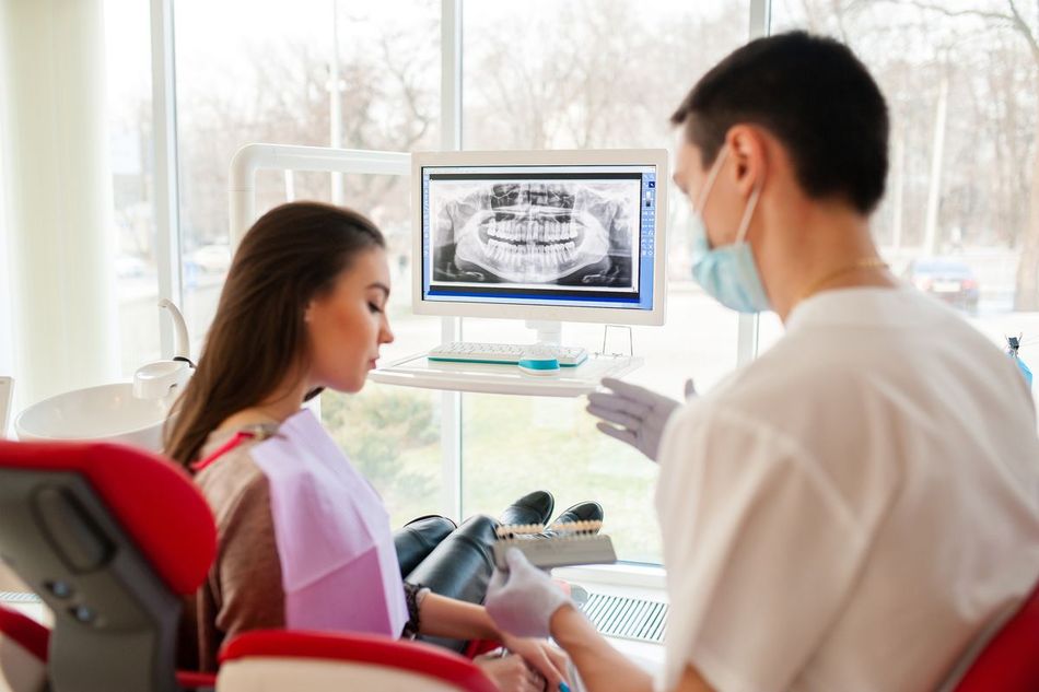 Dentista explicando al cliente la radiografía realizada en la revisión